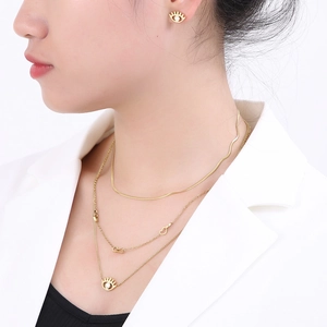 Gold layered heart necklace with eye pendants and matching studs on female model