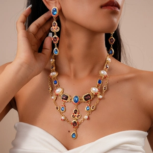 Baroque style jewelry set with blue crystal pendants and pearls shown on a model