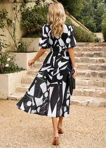 Vue de dos d'une robe mi-longue à imprimé géométrique noir et blanc et manches bouffantes