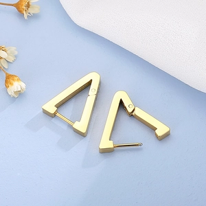 Macro shot of geometric triangle hoop earrings in polished gold stainless steel
