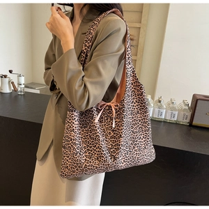 Detail of trendy leopard print shoulder bag with a pink bow accent for women