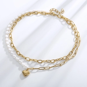 Detail of double-layered gold necklace with heart pendant and freshwater pearls