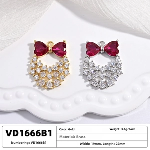 Detailed view of red heart-shaped bow pendants in gold and silver brass with zircons