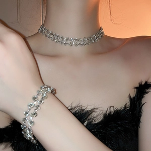 Elegant silver layered necklace and bracelet set with crystal stones on a female model