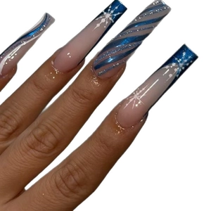 Long coffin press-on nails featuring blue snowflake patterns and sparkling glitter