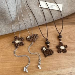 Detailed flat lay of leopard print heart and flower pendants with crystal accents
