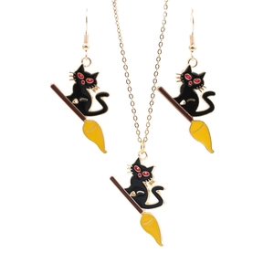 Détail de parure Halloween avec collier et boucles d'oreilles chat noir sur balai