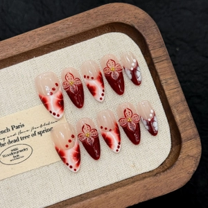 Handmade tropical flower press-on nails with red 3D floral accents on almond shapes