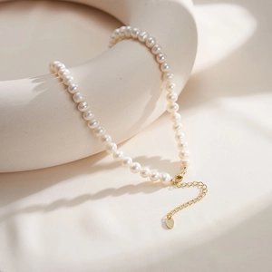 Detail of elegant natural freshwater pearl necklace with gold lobster clasp and extension chain