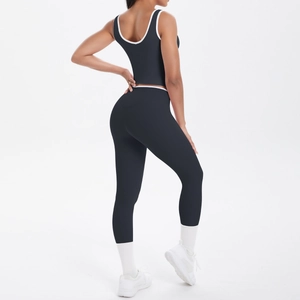 Rear view of black high-waisted yoga leggings and sports bra set with white piping