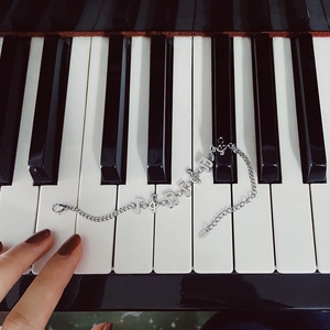 Artistic silver music note charm bracelet on piano keys made of stainless steel