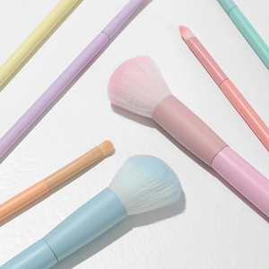 Detailed flat lay of macaron-colored makeup brush set with soft dense bristles on white back