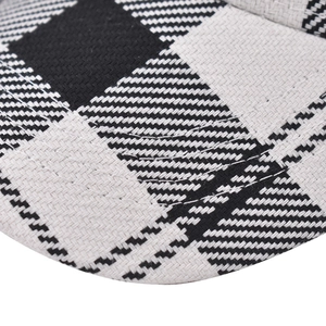 Close-up of black and white houndstooth fabric with parallel stitching on baseball cap brim