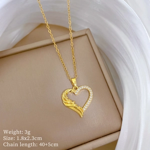 Close-up of gold heart necklace with wing texture and pavé zircon on beige jewelry box