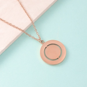 Detailed macro of rose gold spinning geometric double circle pendant on a fine chain
