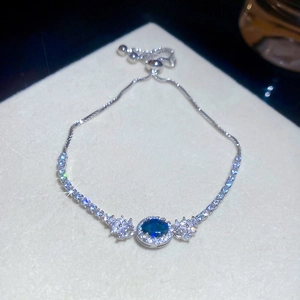 Detaillierte Makroansicht eines silbernen Armbands mit ovalem blauem Stein und Zirkonia