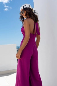 Side view of halter neck backless wide-leg jumpsuit in deep purple textured fabric