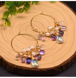 Detail of freshwater pearl and iridescent bead fringe on gold hoop earrings for women