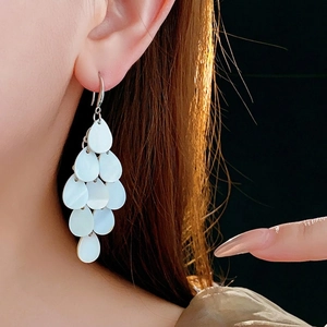 Teardrop shell tassel earrings with layered white mother-of-pearl charms on silver hooks