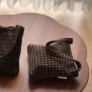 Detail of wool fabric texture on mini tote bags with houndstooth and stripe patterns