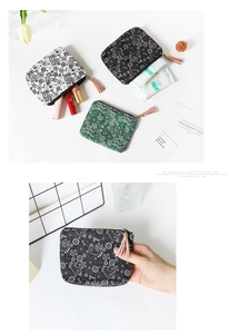 Detailed view of canvas coin purses with paisley pattern, zipper, and tassel charms