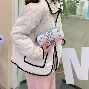 Detail of cute bear printed canvas pencil case held by a model in a modern store setting