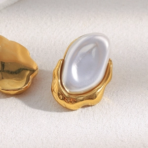 Detail of 18K gold plated earring featuring a white baroque pearl on textured metal base
