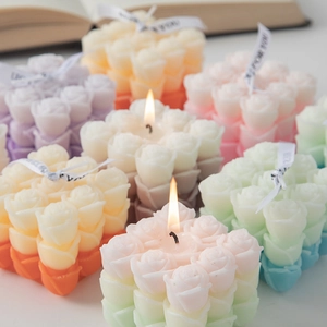 Scented multi-head rose bouquet candle in pastel colors with lit wick for home decor
