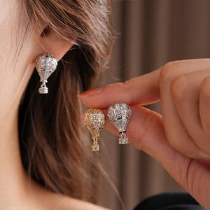 Gros plan de boucles d'oreilles montgolfière en zircone cubique dorées et argentées