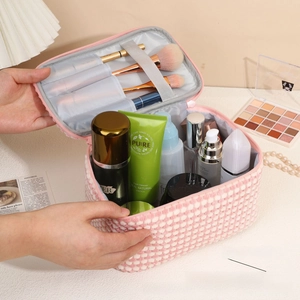 Detail of pink plaid plush makeup bag showing brush slots and large main storage