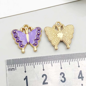 Detailed view of purple enamel butterfly charms in gold alloy with metric measurement