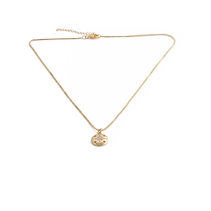 Détail du pendentif boussole doré serti de zircons avec gravures des points NESW