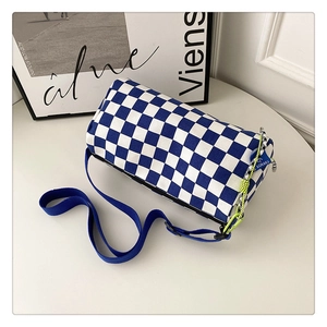 Detailed top view of a blue and white checkered Boston bag with woven yellow strap detail