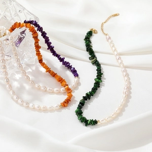 Elegant natural pearl and colorful gemstone gravel necklaces on white satin background