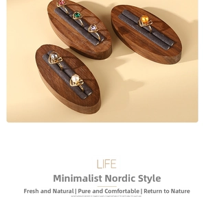 Close-up of pearl rings with heart frames on a walnut wood display stand for jewelry