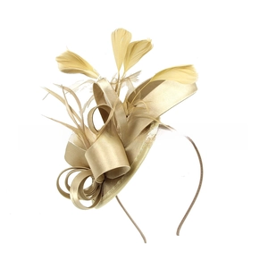 Detailed close-up of champagne gold satin ribbons and elegant feathers on a formal headband