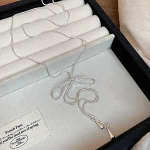 Détail du collier noeud en argent avec chaîne serpent et pendentifs gouttes d'eau chic