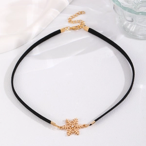 Detailed close-up of a velvet choker featuring a gold snowflake pendant with a clear gemstone