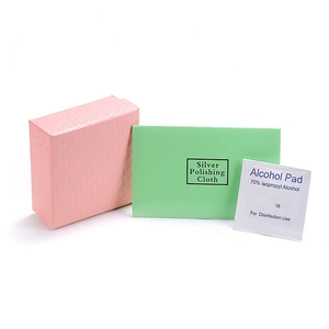 Pink jewelry gift box with green silver polishing cloth and alcohol cleaning pad detail