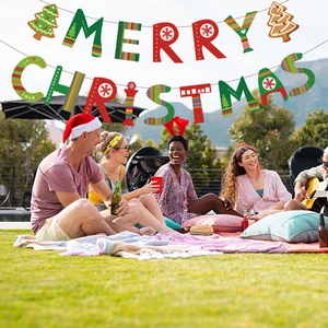 Outdoor scene of friends gathering under a colorful Merry Christmas letter banner