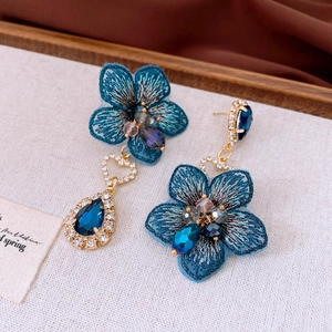 Close-up of blue embroidery flower earrings with water-drop crystal and heart links