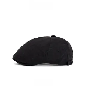 Side view of black vintage flat cap with adjustable bronze metal buckle and fabric texture