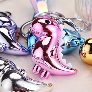 Macro shot of colorful metallic dinosaur keychains with polished finish and silver ring