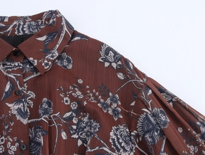 Detailed view of floral chiffon dress with lapel collar, buttons and puff sleeve texture