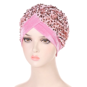 Detail of pink velvet turban hat featuring sparkling rose gold sequins and cross knot design