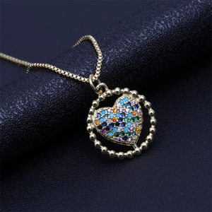 Macro shot of gold heart pendant necklace featuring colorful zircon micro-pave crystals