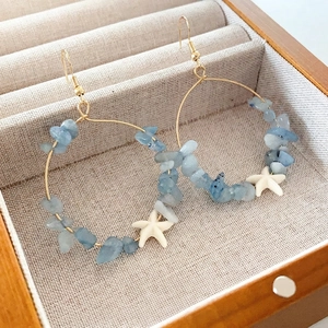 Gold circular starfish earrings with blue aquamarine stones for beach vacation style