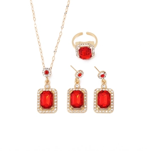 Golden jewelry set with red rectangle crystals and white rhinestones on white background