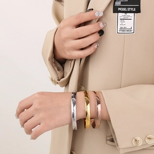 Classic stainless steel bangle set in silver, gold, and rose gold on a model's wrist