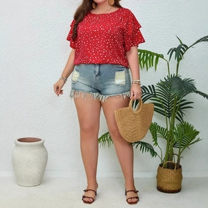 Detail of plus size red polka dot ruffle sleeve top and distressed denim shorts with straw bag